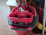 a mop and bucket with cleaning supplies on the floor