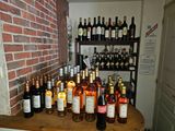 many bottles of wine sitting on a table in front of a brick wall