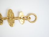 an image of a close up of a gold bracelet on a white surface