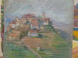 someone is holding a painting of a small town on top of a hill