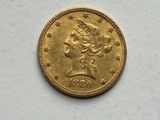 a close up of a gold coin on a white surface