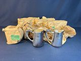 three silver pitchers and a bag of tea on a blue background