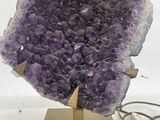 purple amethorate on a wooden stand with a lamp on a white background
