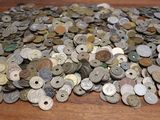 a pile of old coins on a wooden table