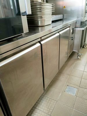 une cuisine avec des placards en inox et beaucoup de vaisselle sur le plan de travail