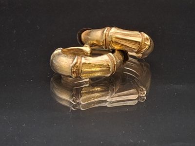 a pair of gold cufflinks on a black surface
