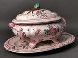 a white and pink tureeny dish with a green leaf on top