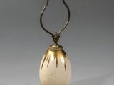 une lampe à l'ancienne, dotée d'un abat-jour en verre blanc posé sur un socle en bois