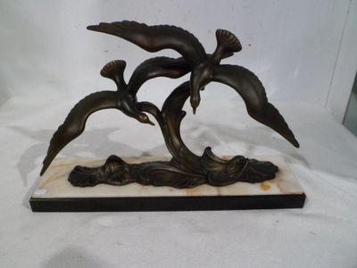 a bronze statue of three birds on a marble base