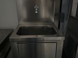 a stainless steel sink in the corner of a kitchen