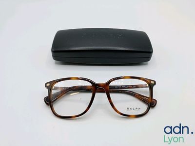 les lunettes se trouvent à côté d'un étui noir, posées sur une surface blanche