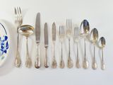 a lot of silverware on the table and a plate