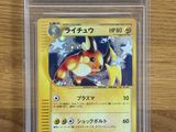 une carte Pokémon dans un étui en plastique posé sur une table en bois