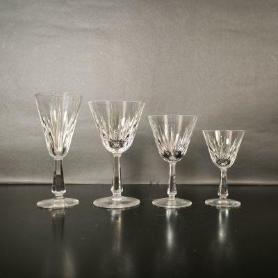 Quatre verres à vin sont alignés sur une table noire