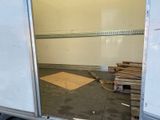 a room with a door open and a pile of wood on the floor