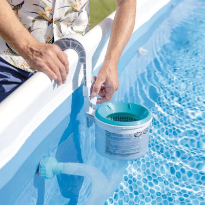 someone using a hose to clean a pool with a bucket of water