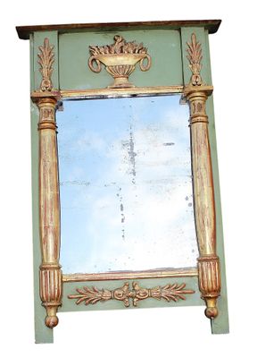 a mirror on the wall that has a vase on top of it
