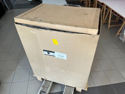 a cardboard box sitting on top of a cart in the middle of a room