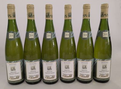 six bouteilles de vin sont alignées sur une table