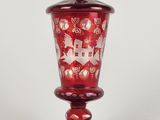 une image représentant un vase en verre rouge orné d'une scène de Noël