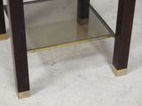 a small glass table with a metal base and a glass top
