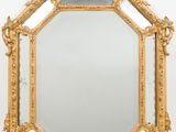 an ornately carved mirror with a gold frame on a white background