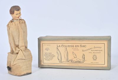 une petite statue en bois représentant un homme assis sur une caisse