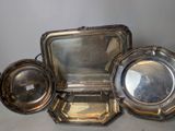 three silver trays and a mirror sitting on a table