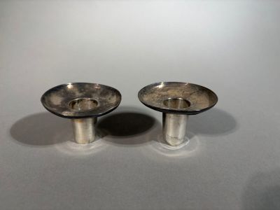pair of silver plated candlestick holders on a white surface