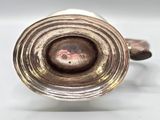 an image of a silver cup with a handle on a white surface