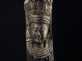 une tête de femme en bronze, coiffée d'une couronne, sur fond noir