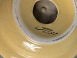 a yellow vase with a black and white label on it