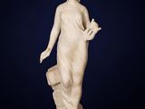 une statue en marbre blanc représentant une femme tenant un seau