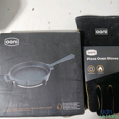 une boîte de gants de cuisine pour four à pizza à côté d'une paire de gants