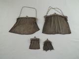 two brown purses and a small purse on a white surface