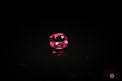 a close up of a pink diamond on a black surface
