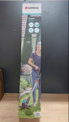 la boîte de la tondeuse à gazon filaire est ouverte sur la table