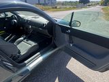a car with its door open sitting on the side of the road