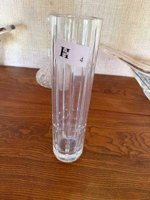 un vase en verre transparent posé sur une table, avec une étiquette portant un nom