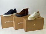 three pairs of shoes in boxes on a white background