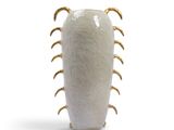 a white vase with gold spiky spikes on it