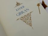 un livre ouvert, sur lequel repose une clé, posé sur une table