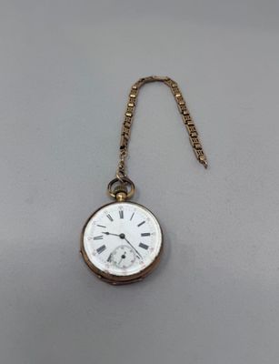 une montre de poche ancienne à laquelle est accrochée une chaîne sur le côté