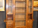 a wooden cabinet with a glass door in the middle of a room