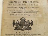 un vieux livre avec l'image d'un blason