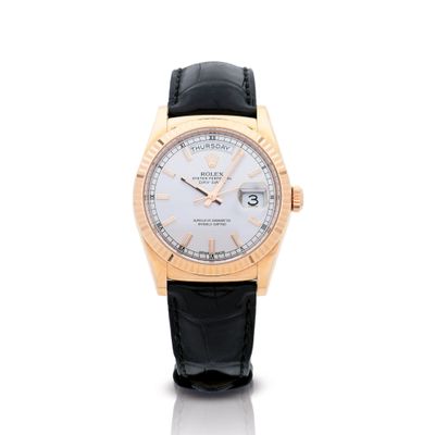 un gros plan d'une montre au cadran blanc et au bracelet en cuir noir