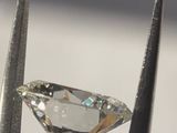a close up of a diamond being held by a pair of pliers