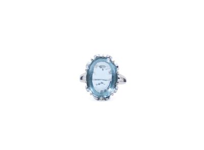 a close up of a ring with a blue stone in it