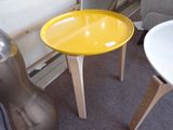 une petite table jaune sur laquelle se trouve un plateau jaune