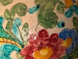a vase with a flower design on it sitting on a table